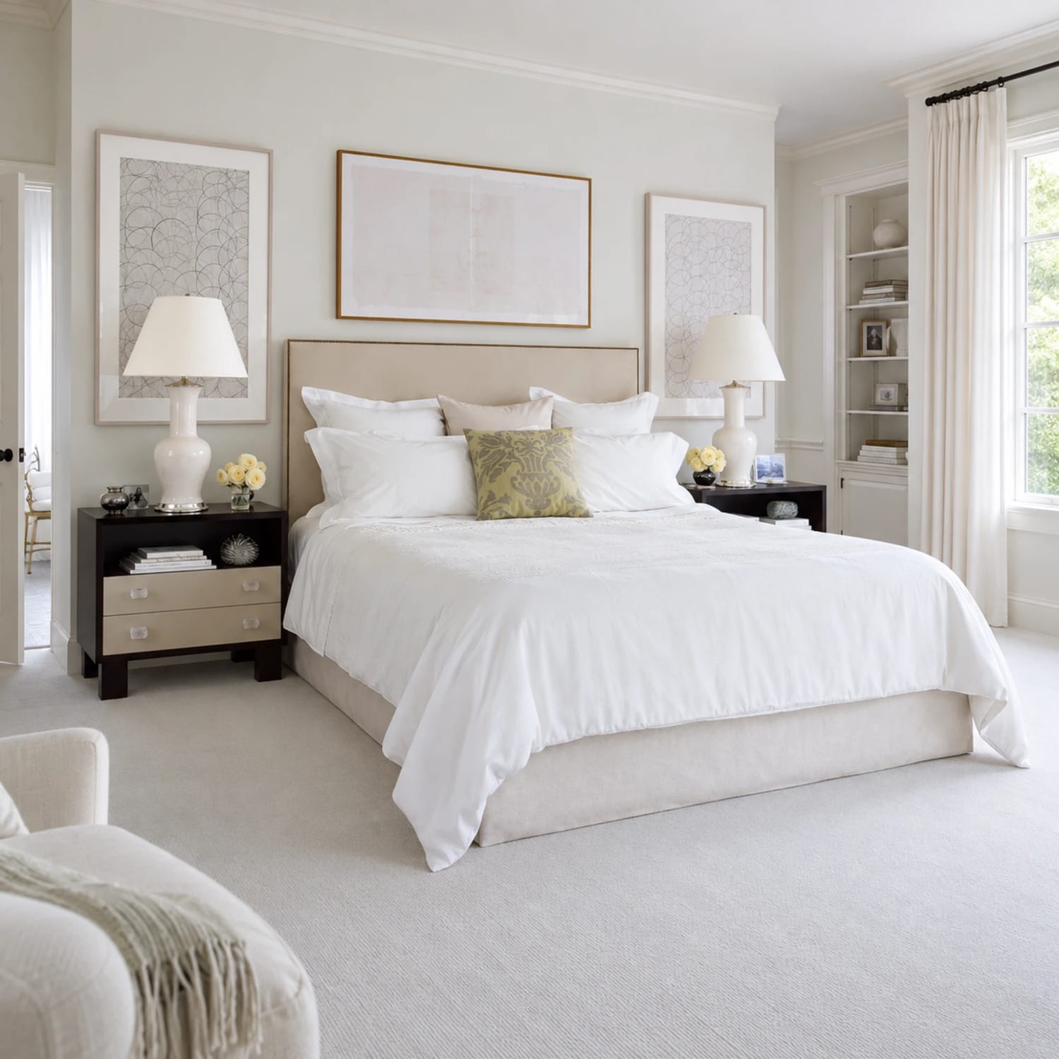 Staged primary bedroom in soft neutrals with white bedding and matching lamps