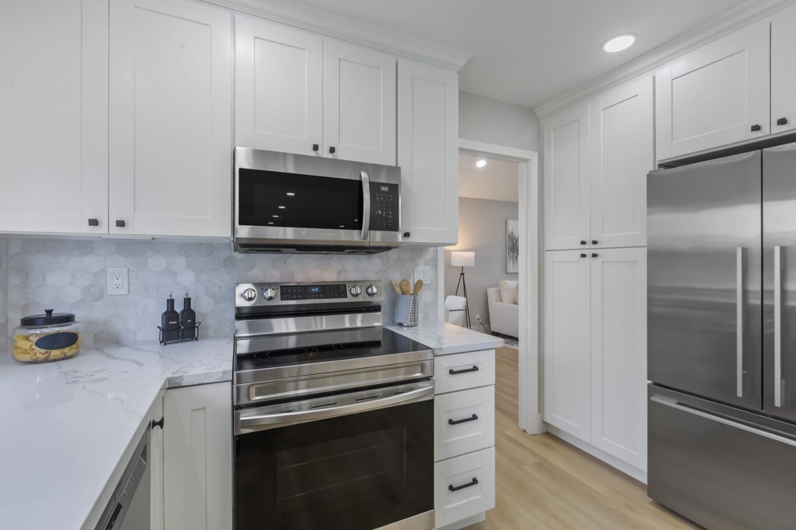 Kitchen detail: stainless range and microwave, pantry cabinets and a French-door refrigerator